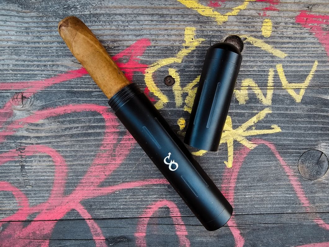 Protective tube for cigars on wooden table with graffiti